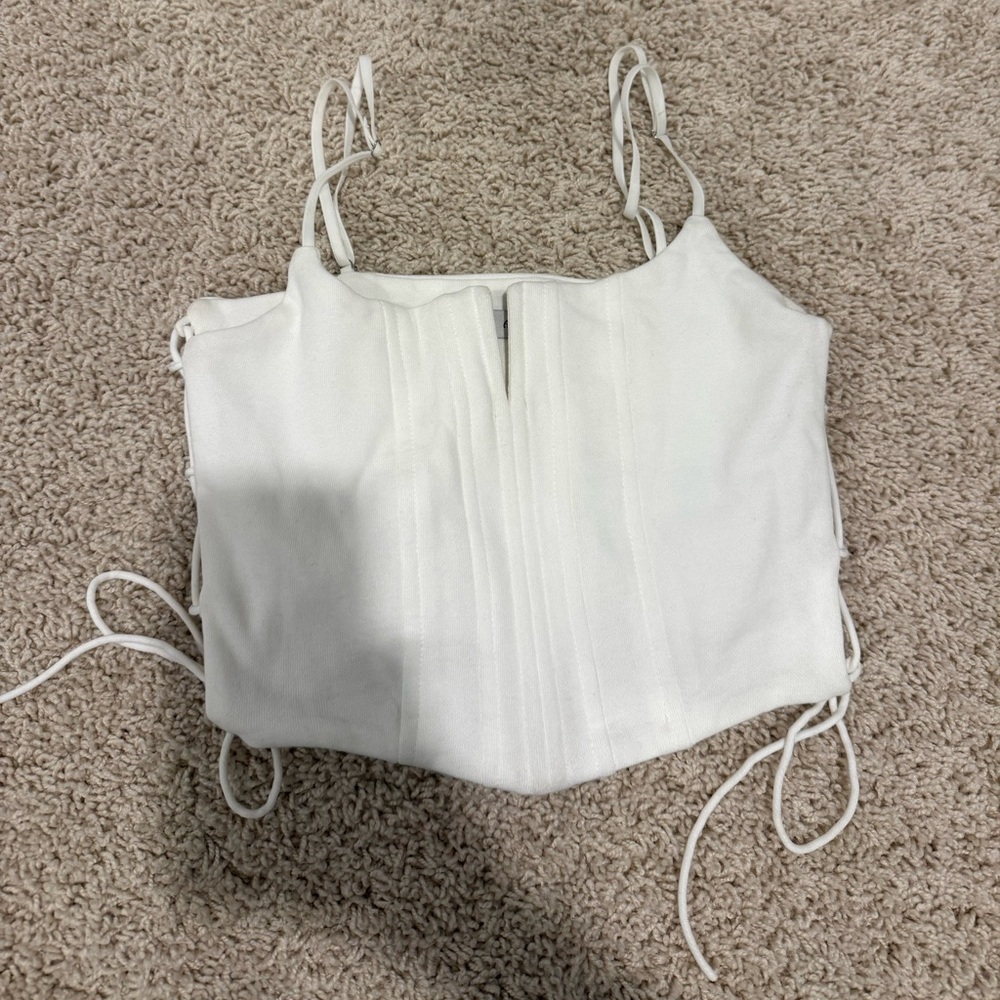 White cropped top with lace up detailing on either side. Size small, never worn.